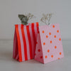 Rosa Geschenktüten mit roten Streifen und Punkten, stilvolle Papierbeutel für kleine Geschenke