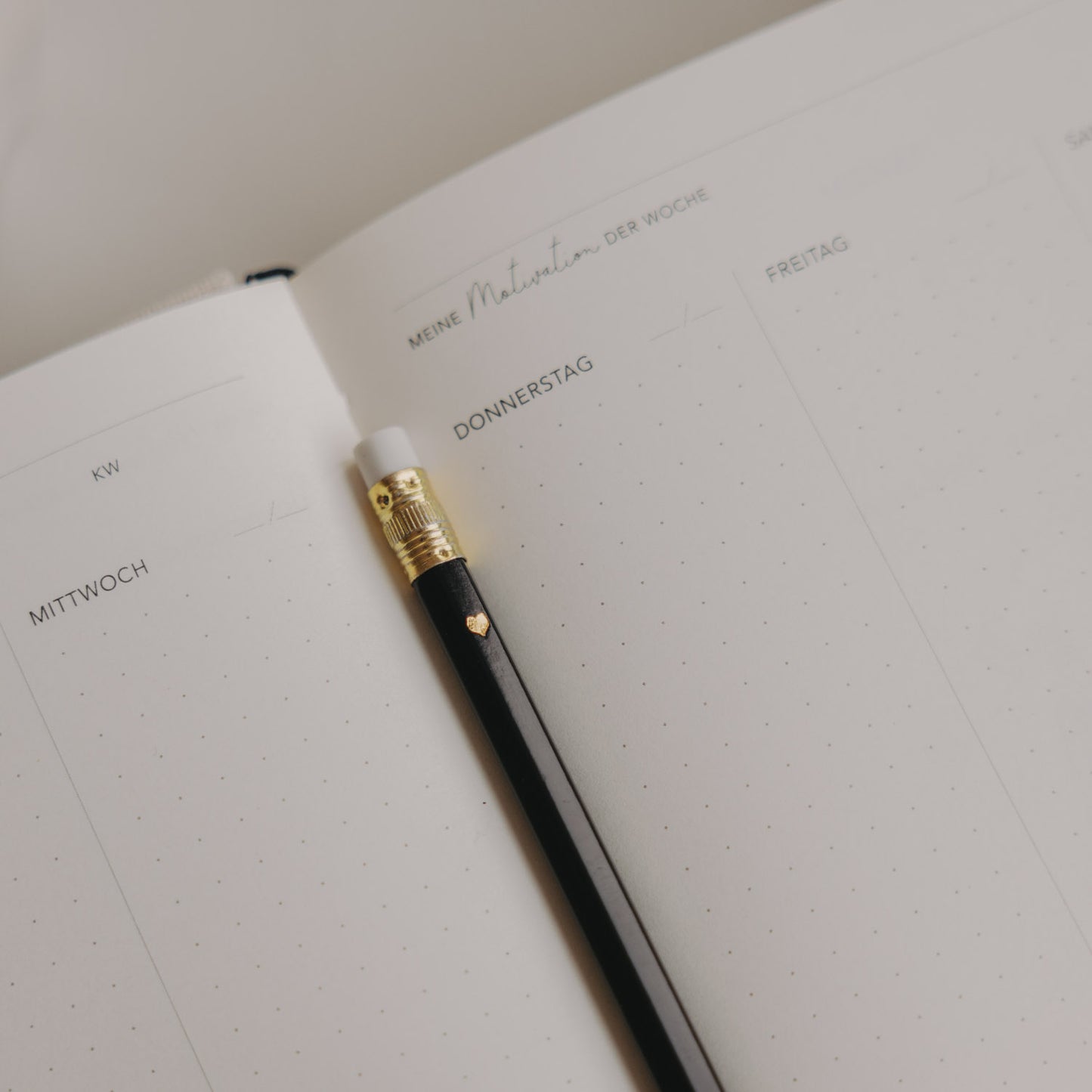 Schwarzer Bleistift mit Herzdetail auf Wochenplaner