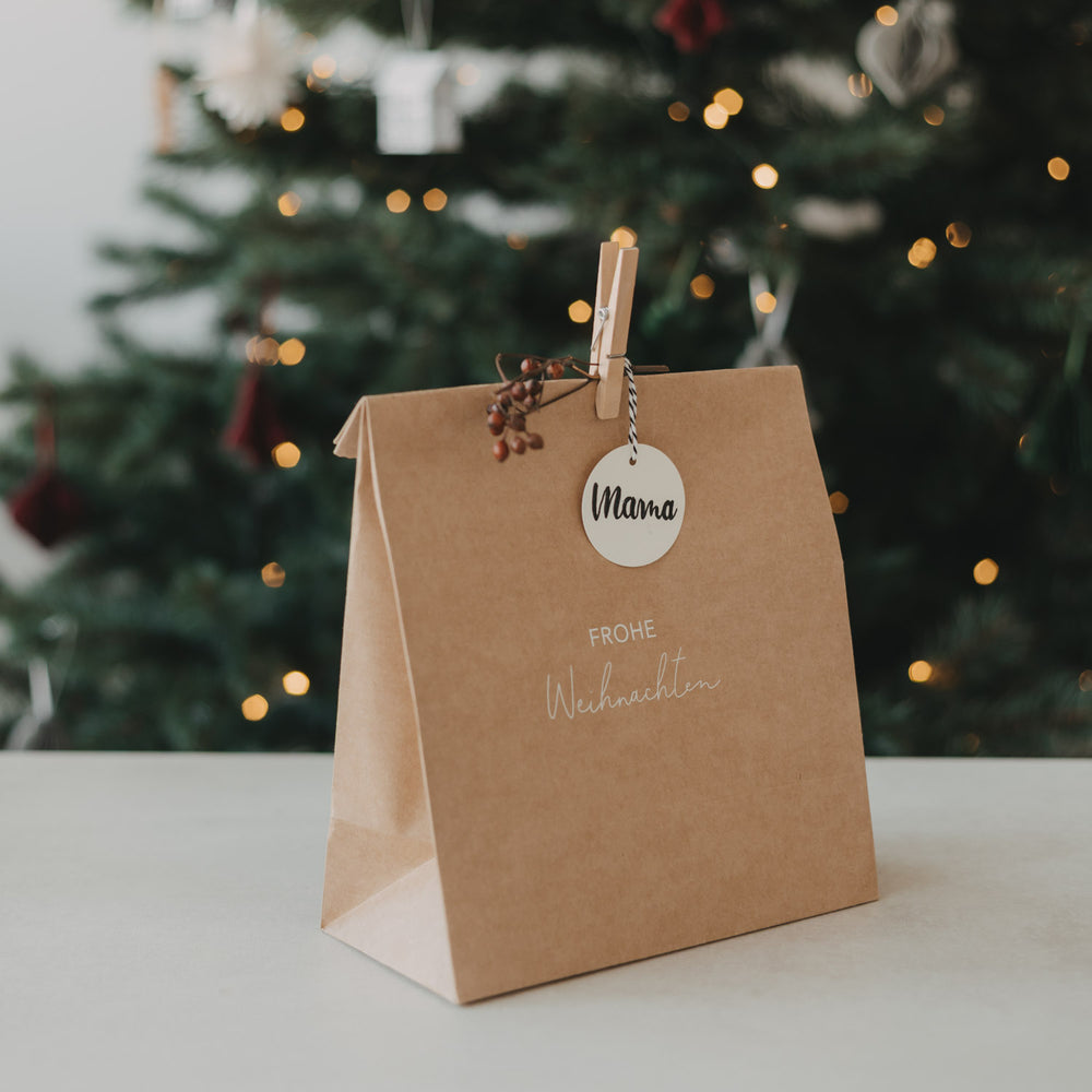 Kraftpapier-Geschenktüte mit „Frohe Weihnachten“, Holzklammer, Beerenzweig und Geschenkanhänger „Mama“