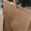 Weihnachtliche Kraftpapier-Geschenktüte mit Schriftzug „Für dich“ und weißer Häuserillustration