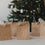 Weihnachtliche Geschenktüten aus Kraftpapier mit weißen Motiven vor geschmücktem Weihnachtsbaum