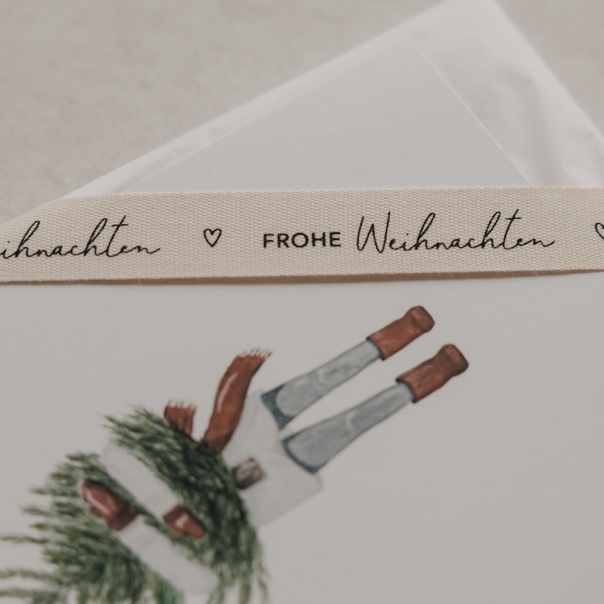 Beiges Geschenkband Frohe Weihnachten von Eulenschnitt mit schwarzem Schriftzug und kleinem Herz