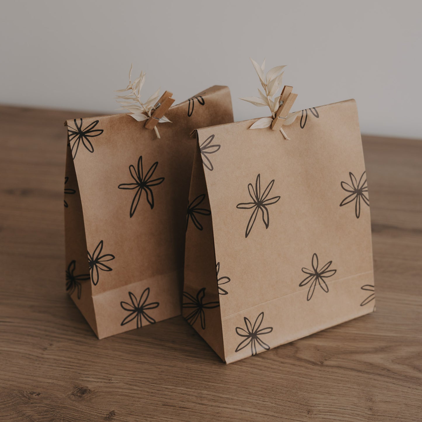 Geschenkbeutel aus Kraftpapier mit grafischem Blumenmuster in Schwarz, minimalistisch und natürlich